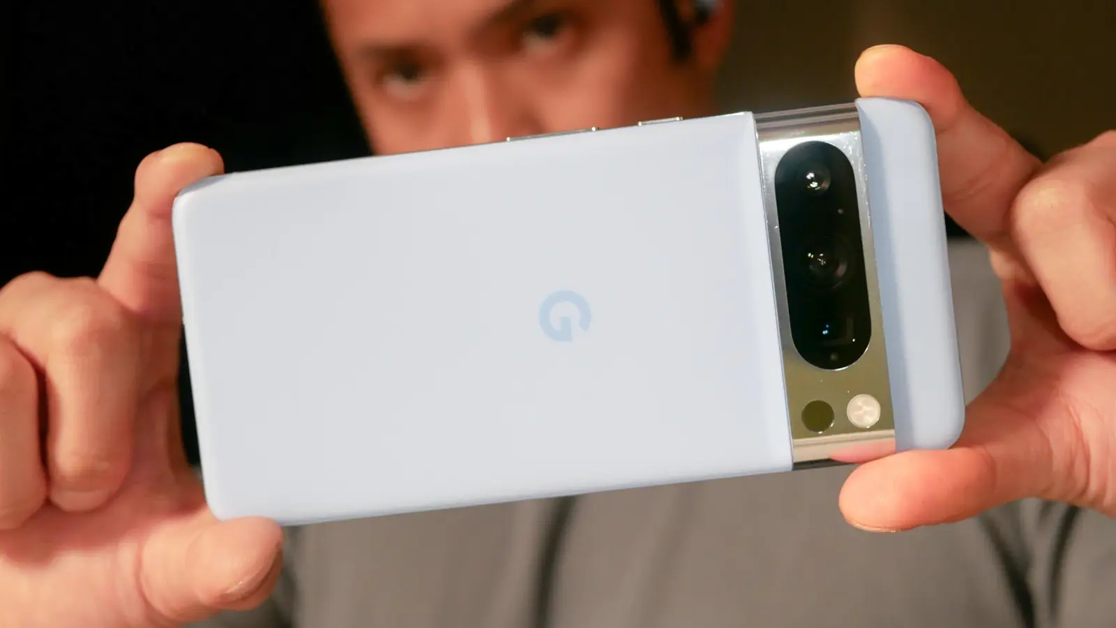 Person holding the ZeroGhost Phone horizontally to take a photo with its triple camera